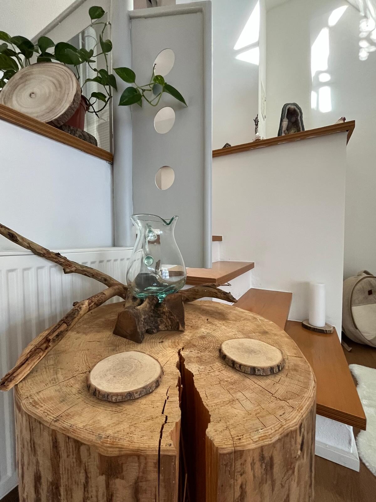 Tisch aus massivem Holz mit Glasobjekt und Wurzelholz am Treppenbereich